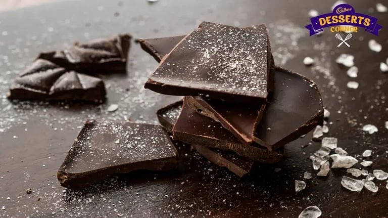 Feature Image - Broken pieces of dark chocolate bark stacked up on a surface