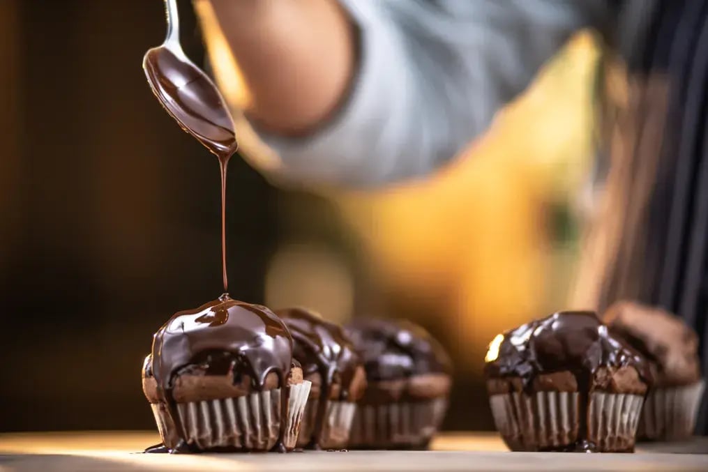 Drizzle of dark chocolate over cupcakes