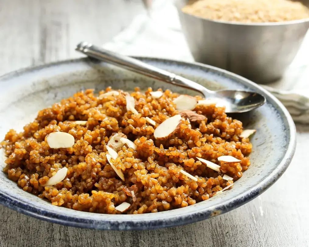 Cardamom Bournville Lapsi With Wheat And Dry Fruits On A Plate