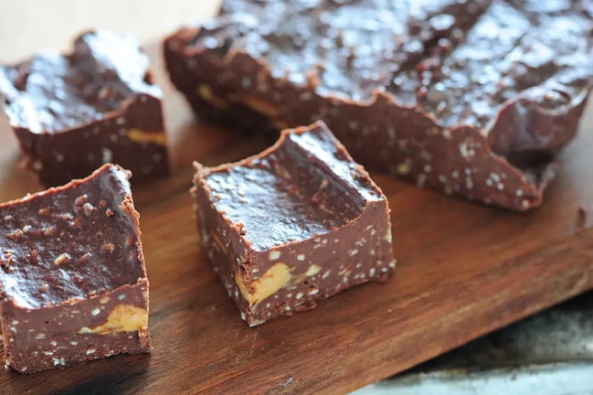 Feature Image - Chocolate Fudge studded with nuts on a brown platter