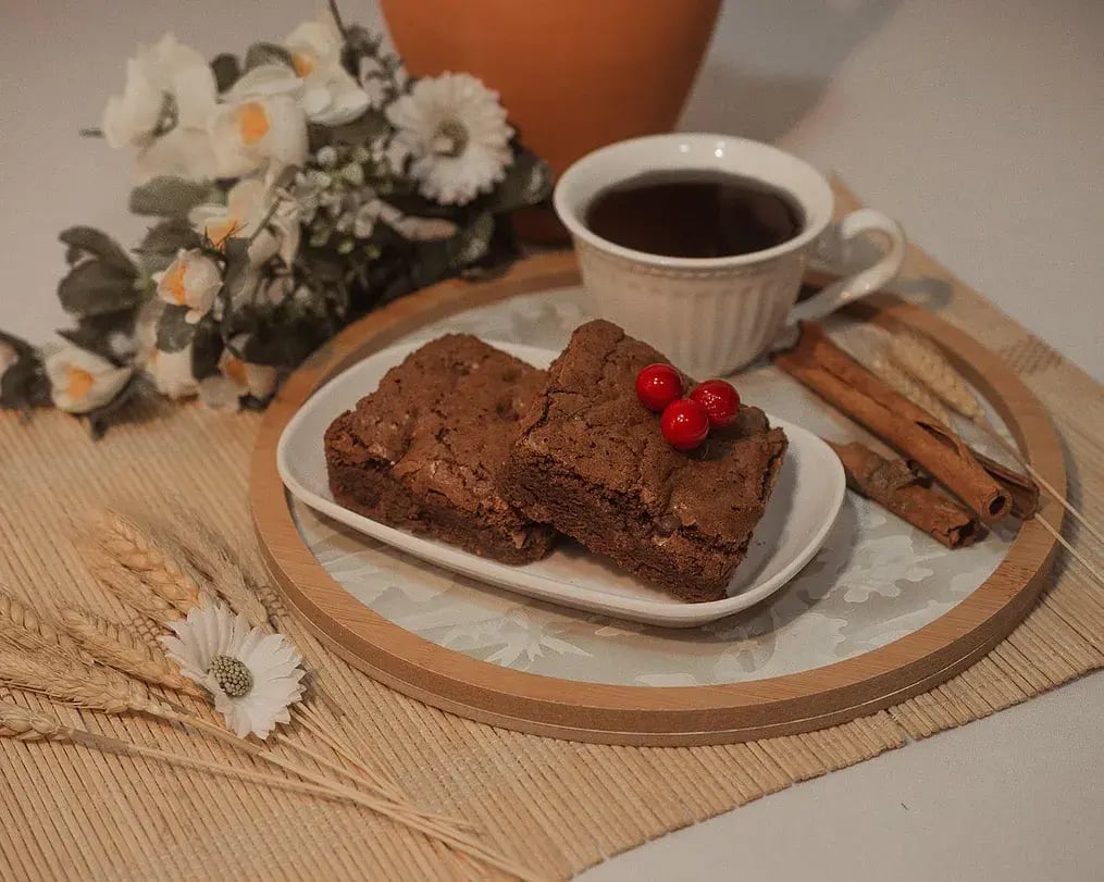 Fudgy Brownies With Dairy Milk And Cherries On A Plate