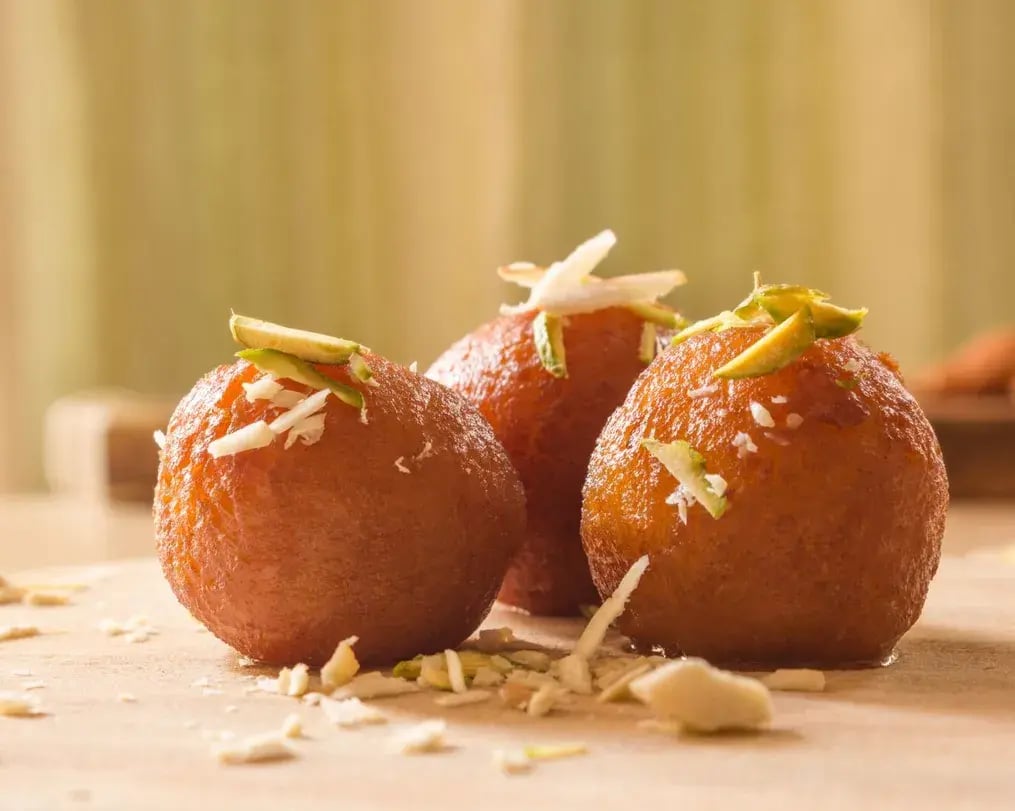 Gulab jamun pieces with almond garnish