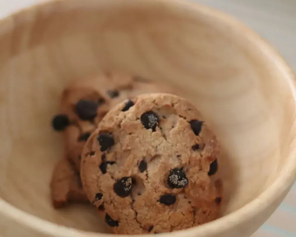 Fresh cookies on parchment with fruits and chocolate