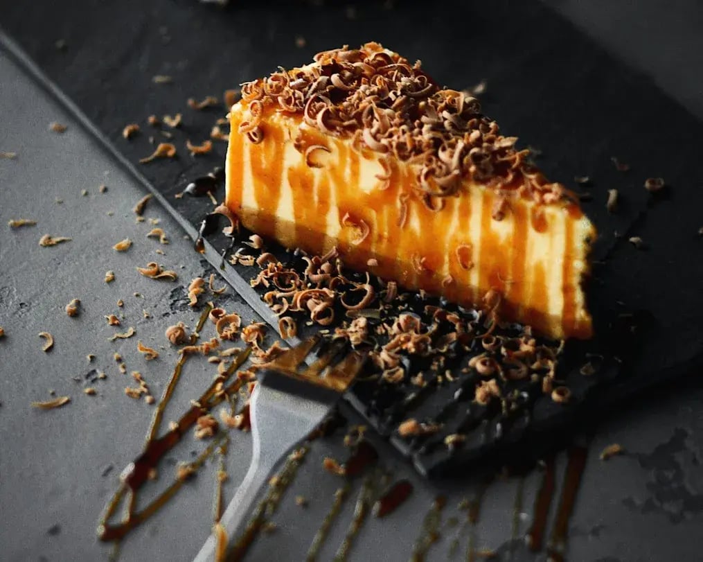 How to Make a Cardamom Chai Cheesecake for International Tea Day - Cardamom Chai Cheesecake with drizzle and chocolate shavings