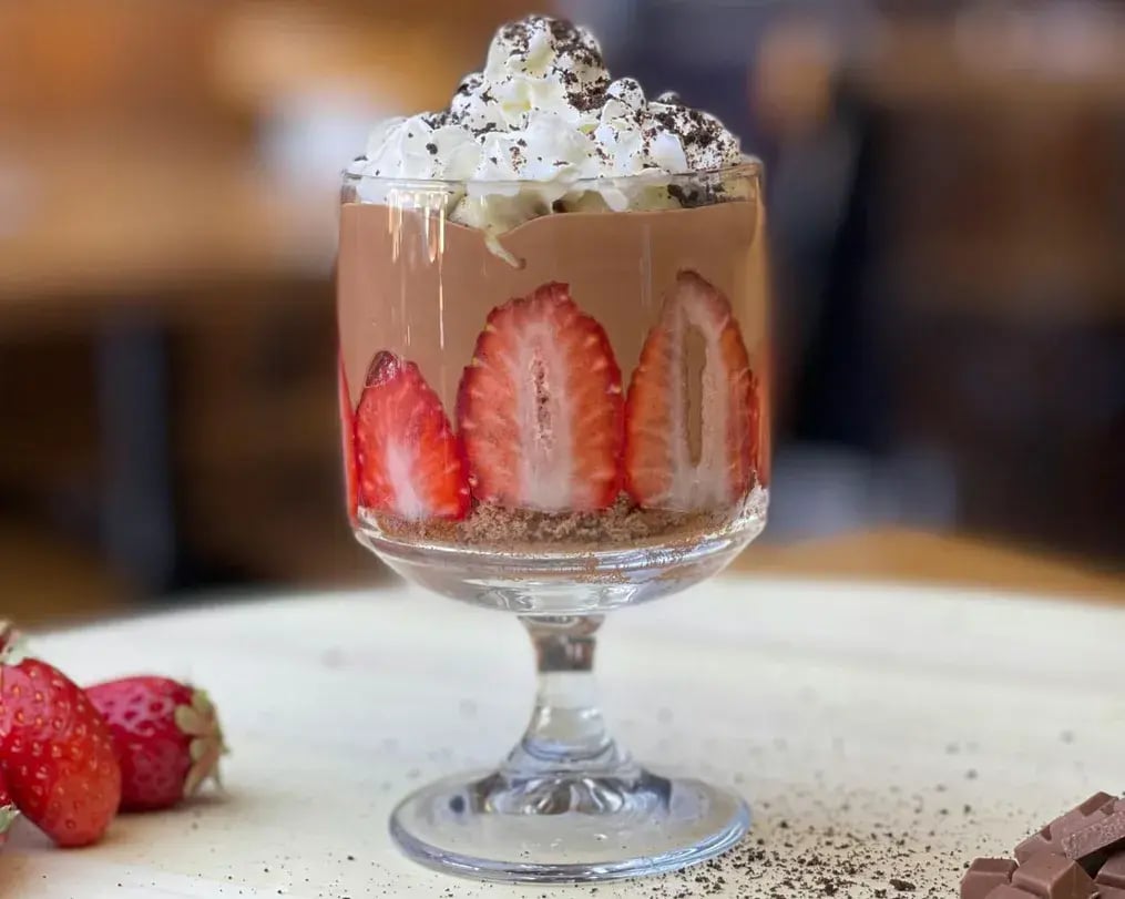 chikoo mousse with walnuts whipped cream and strawberries and chocolate