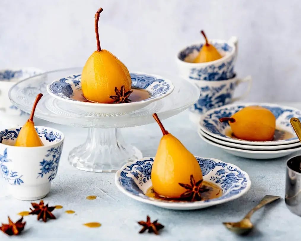 How to Make Elegant Merlot Poached Pears for Wine Day - Whole poached pears on a plate with syrup and star anise