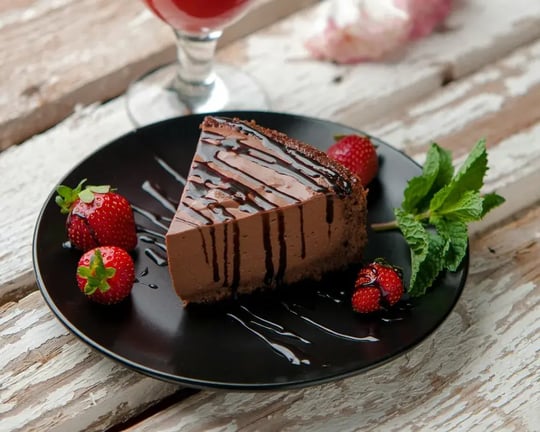 Chocolate Cheesecake With Chocolate Drizzle And Strawberries