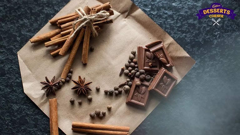 Feature Image - Cubes of dark chocolate with whole spices on the side