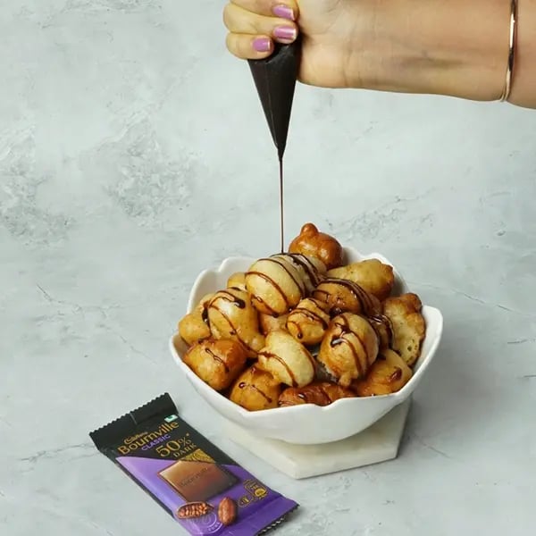 Bournville Cinnamon Lokma-Garnish lokma with melted chocolate over it