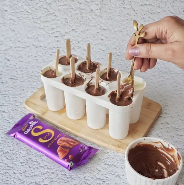 Cadbury Dairy Milk Silk and Mango Layered Kulfi with Cashew Nuts - Pour the melted chocolate on top of the mold