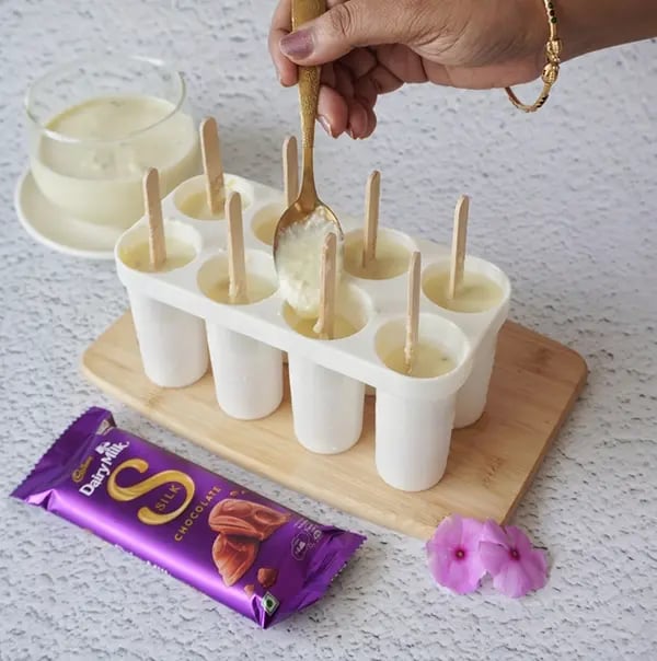 Cadbury Dairy Milk Silk and Mango Layered Kulfi with Cashew Nuts - Pour the rabdi layer in the mango kulfi
