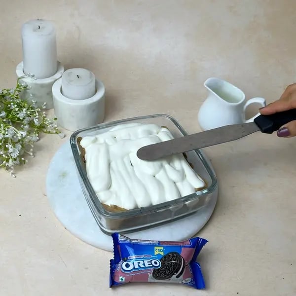 Chocolate Oreo Poke Cake - Spreading Whipped Cream