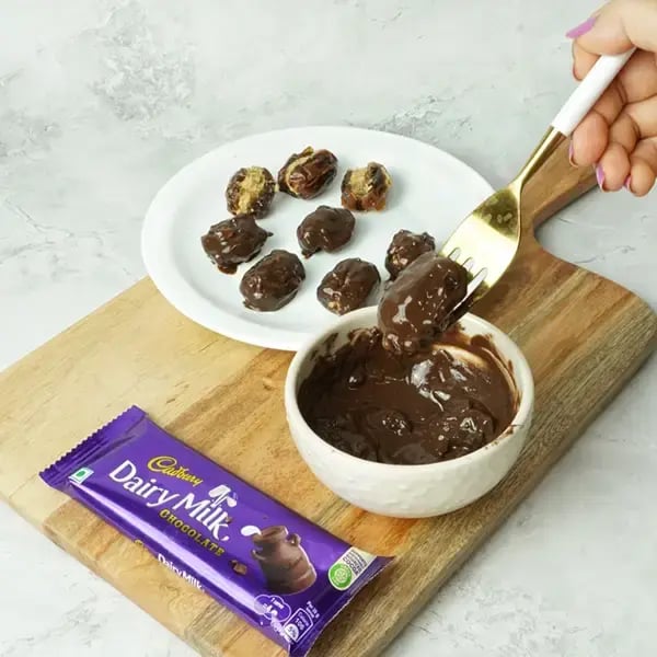 Dairy Milk Coated Peanut Butter Stuffed Dates - Dip each one into the melted chocolate
