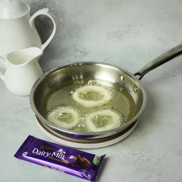 Dairy Milk Glazed Sel Roti- Heat oil in a wide pan