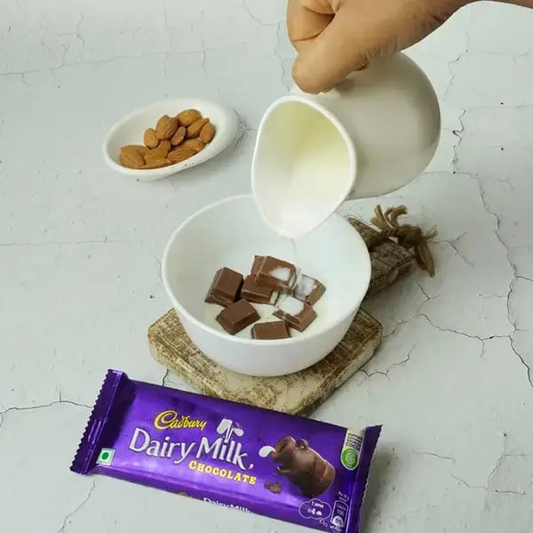 Dairy Milk Quick Fudge Nut Brownie - Combine warm milk and chopped Dairy Milk chocolate