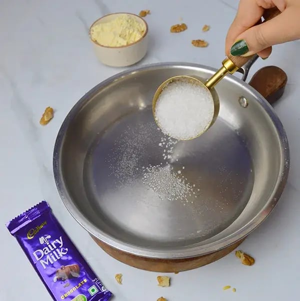 Dairy Milk Walnuts Infused Besan Barfi - Boil water and add sugar
