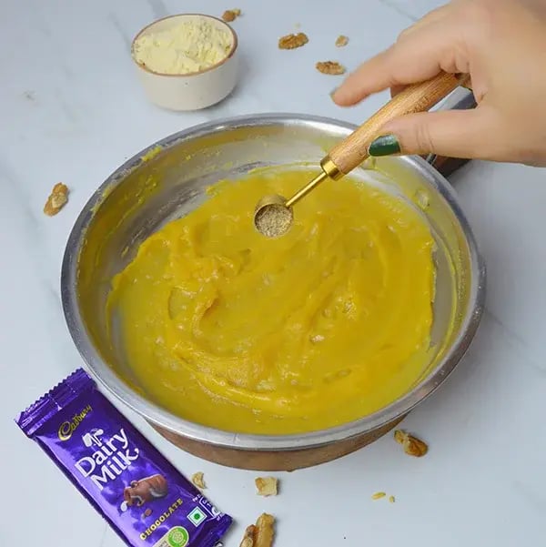 Dairy Milk Walnuts Infused Besan Barfi - Add cardamom powder