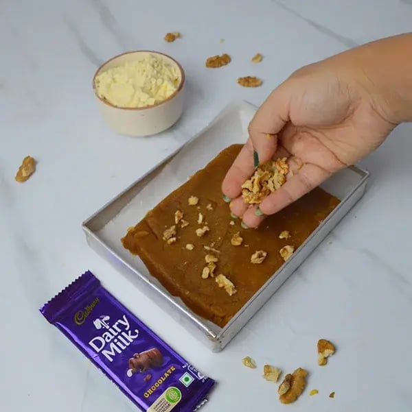Dairy Milk Walnuts Infused Besan Barfi - Sprinkle chopped walnuts