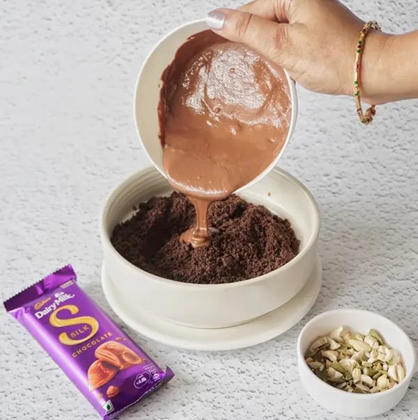 Frozen Silk Chocolate Bites with Nuts and Oreo Crumble - Melted chocolate over the crushed Oreos