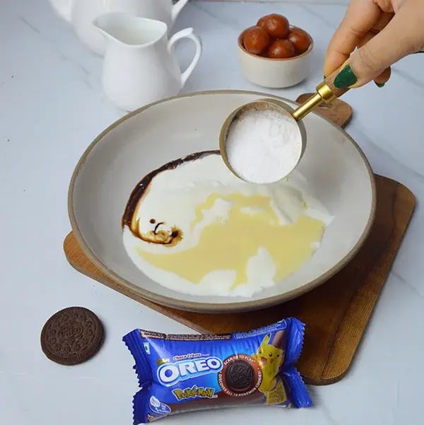 Oreo Crust Gulab Jamun Cheesecake - Combine cream cheese, heavy cream, vanilla essence, condensed milk, and powdered sugar