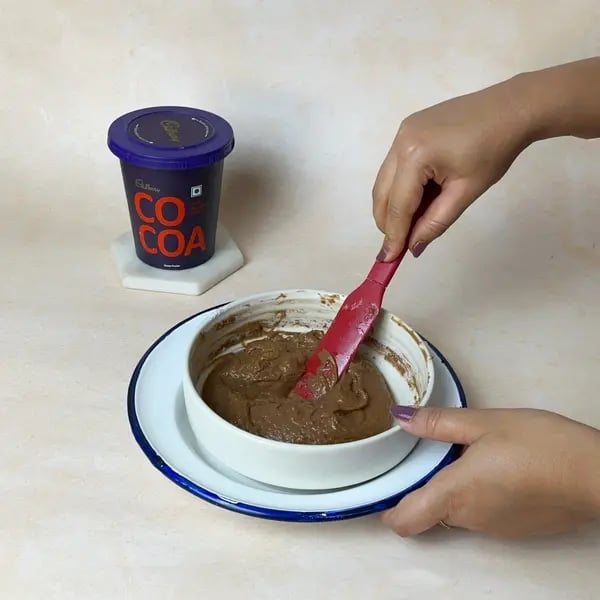 Softest Eggless Cocoa Mango Cake - Folding Batter Gently