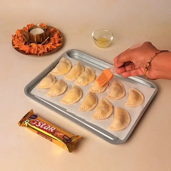 Try This Diwali Special Baked Gujiya Recipe With Cadbury 5 Star For Your Loved Ones - Brushing Gujiyas With Ghee